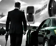 Chauffeur in a suit walking to a black car beside a private jet